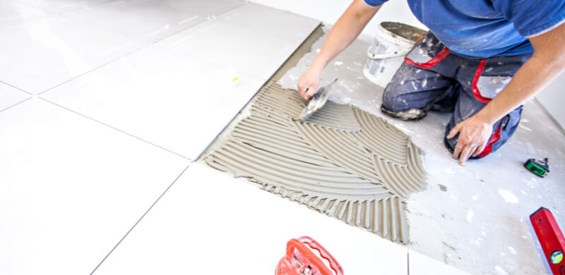 Person tiling a bathroom floor