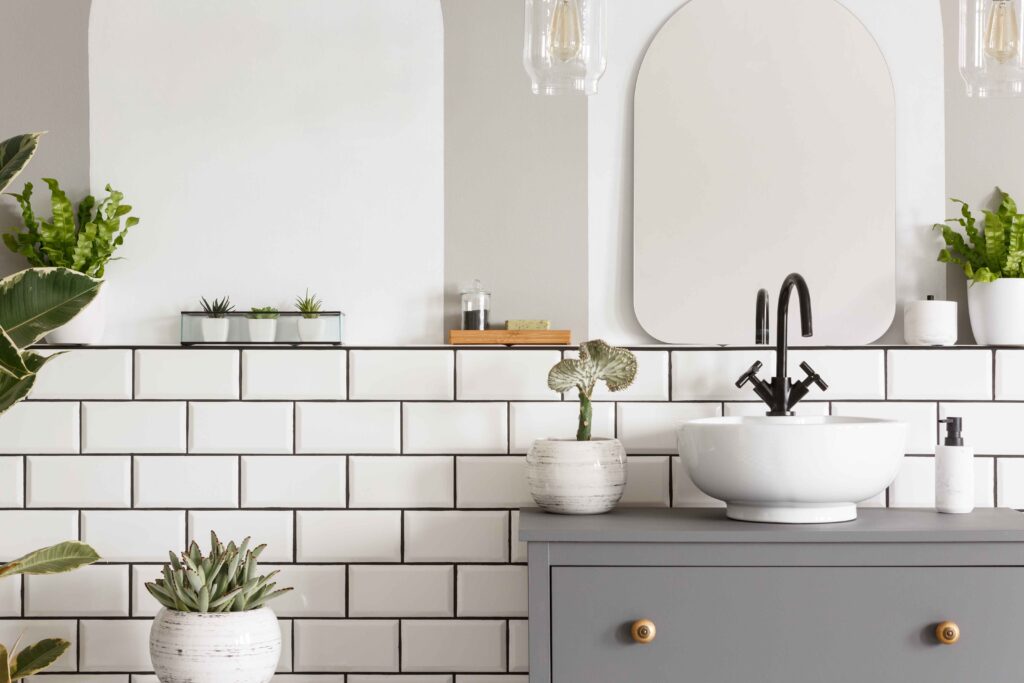 Contemporary half tiled bathroom with white metro tiles, plants, and free-standing sink