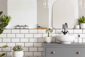 Contemporary half tiled bathroom with white metro tiles, plants, and free-standing sink